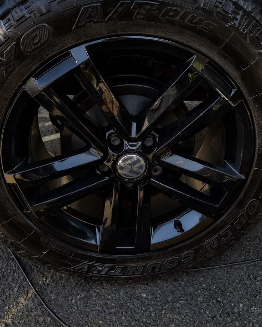 Glossy black Volkswagen alloy wheel and dressed tyre after valeting